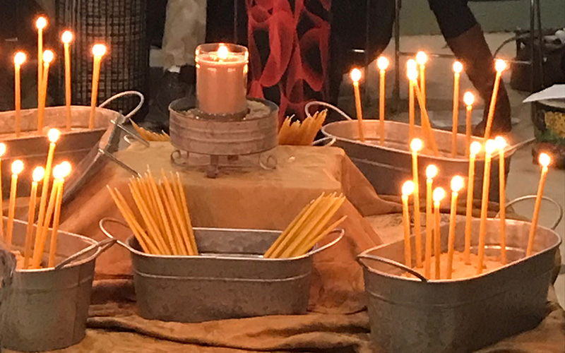 multiple tall candles in metal baskets